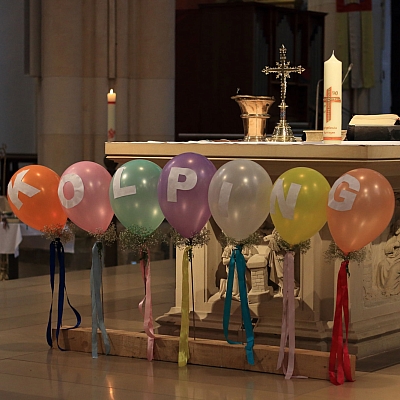 Sieben bunte Luftballons mit dem Wort Kolping vor dem Altar in der St. Agatha Kirche