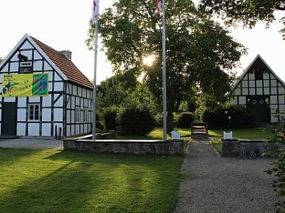 Im Vordergrund frisch gemähter Rasen im Hintergrund der Georgshof mit einem Banner an der Wand. Im Vordergrund frisch gemähter Rasen im Hintergrund der Georgshof mit einem Banner an der Wand.