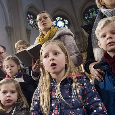 Kleine Kinder singen, dahinter steht die Mutter und hält ein Gotteslob in der Hand. Kleine Kinder singen, dahinter steht die Mutter und hält ein Gotteslob in der Hand.