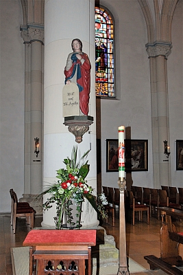Agatha-Statue an der Säule mit festlichem Blumenschmuck