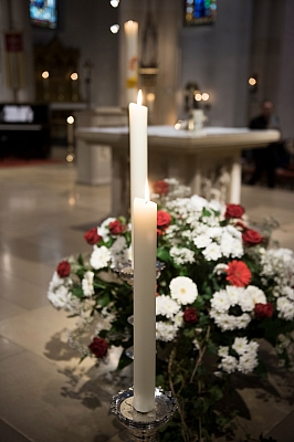 Brennende Kerzen und Blumen in den Farben rot und weiß
