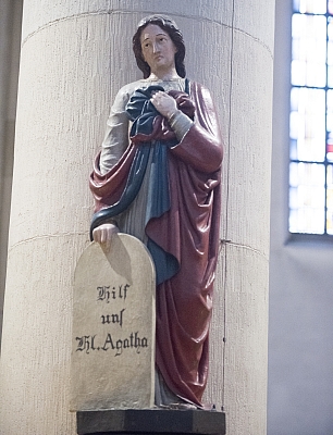 Die Statue der Heiligen Agatha an einer Säule in der Pfarrkirche.