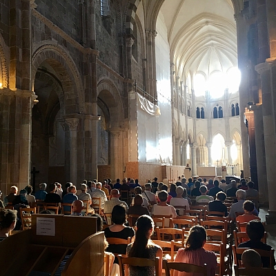 Viele Menschen sitzen auf Stühlen und beten in der Basilika Marie Madeleine Vézelay Viele Menschen sitzen auf Stühlen und beten in der Basilika Marie Madeleine Vézelay