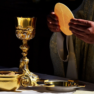 Das Brot wird gesprochen ein goldener Kelch mit Wein steht auf dem Altar Das Brot wird gesprochen ein goldener Kelch mit Wein steht auf dem Altar