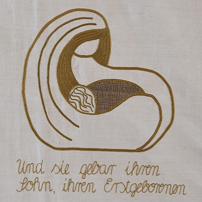 Gesticktes Bild im Hungertuch: Die Mutter Gottes hält den König des Friedens in ihren Armen geborgen.