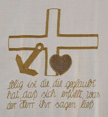 Gesticktes Bild im Hungertuch: Glaube (Kreuz), Hoffnung (Anker) und Liebe (Herz), die drei Grundtugenden des christlichen Glaubens zeigt dieses Bild. 