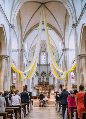 Blick zum Altarraum in die mit gelb weißen Bändern geschmückte Kirche