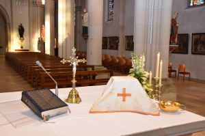 Altar mit Messbuch, Stehkreuz und Kelch mit Velum.