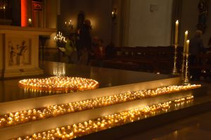 St. Agatha Altar bund beleuchtet davor ein Herz aus Kerzen.